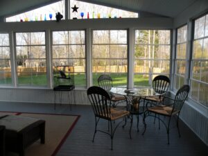 inside a screened porch with a round table and four chairs and stars on windows