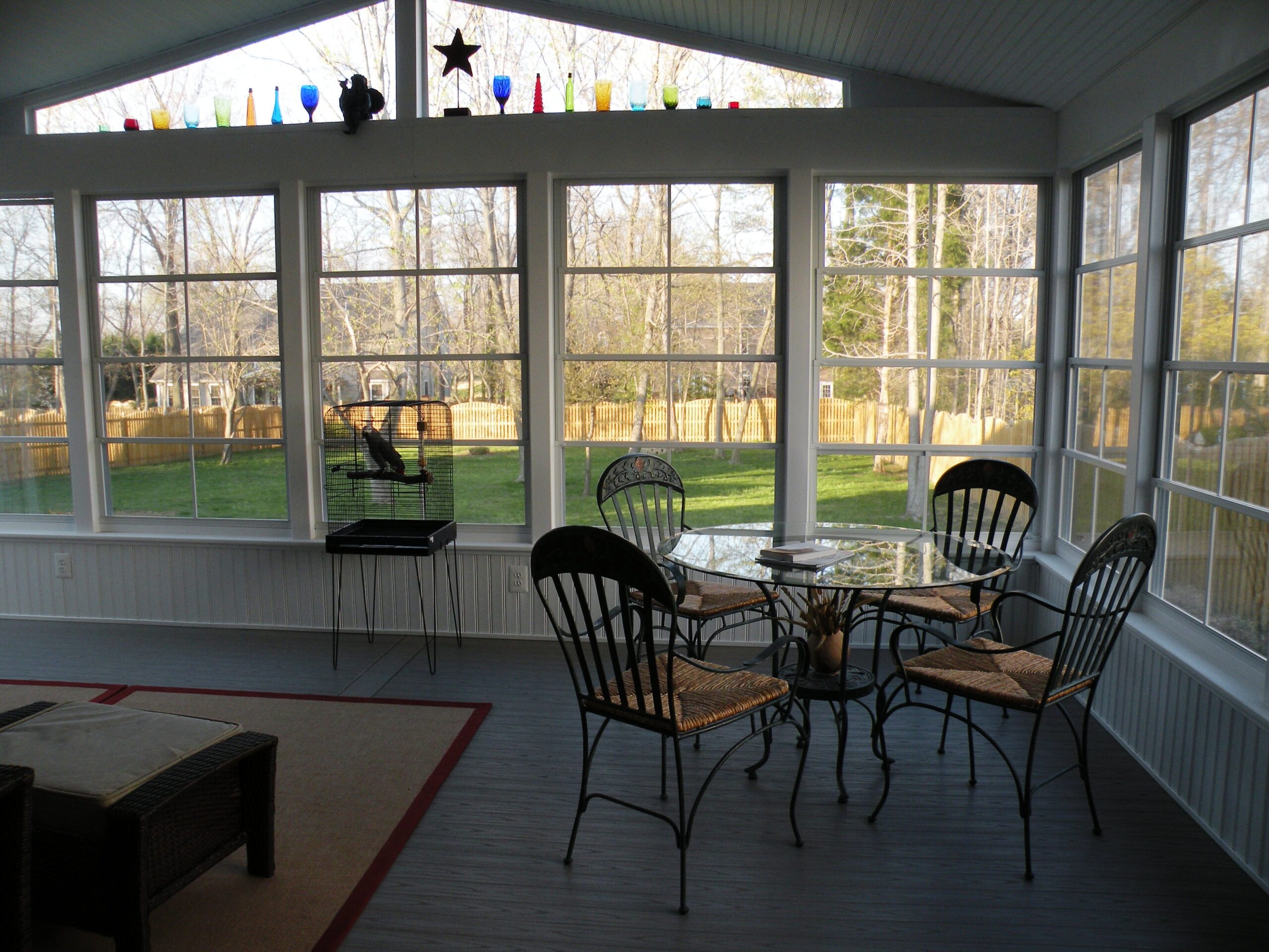 inside a screened porch with a round table and four chairs and stars on windows